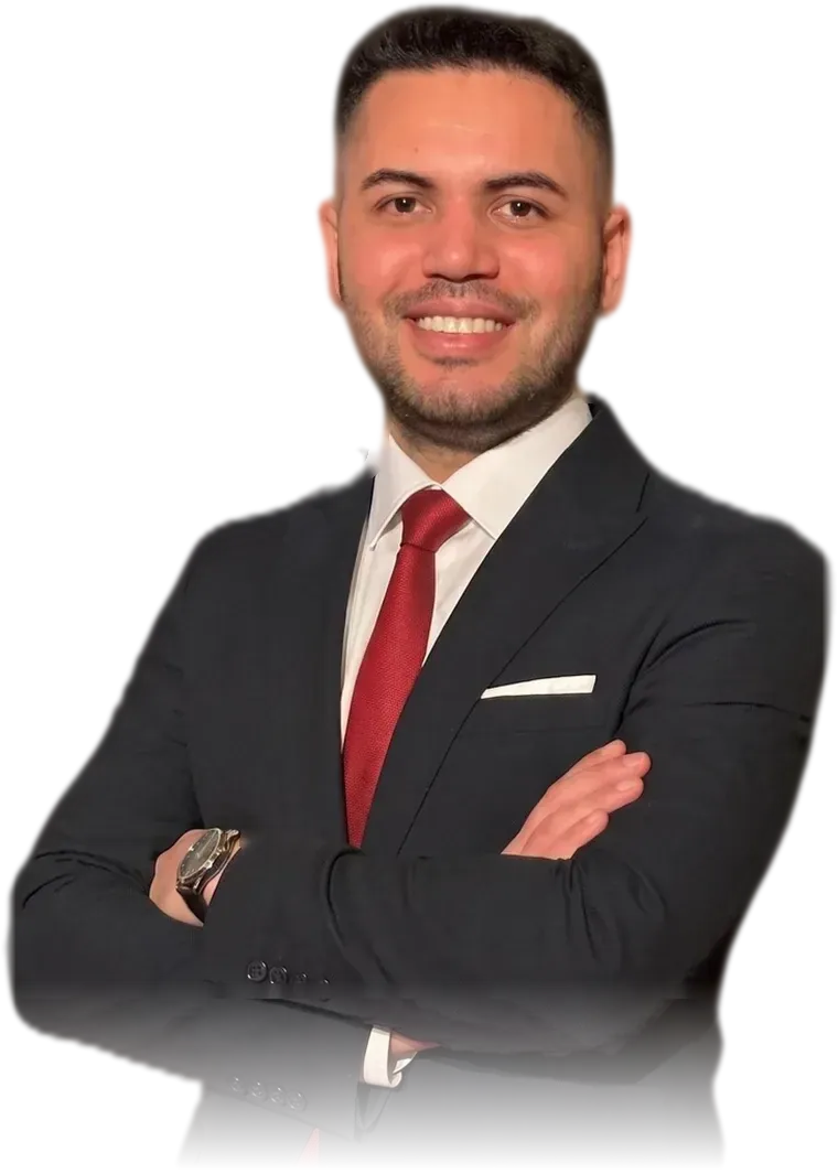 Psikolog Umut Çınar, takım elbiseyle, kollarını kavuşturmuş gülümsüyor